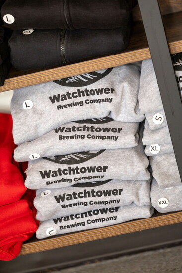 Tee shirts on a shelf at Watchtower Brewing. Photo Credit: Kerry Paradis Photography