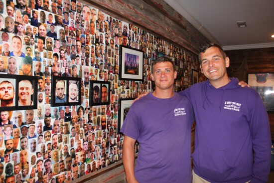 Dustin Owens and Andrew Perez by the wall filled with pictures of former residents. More than 2500 men have been through the program. 