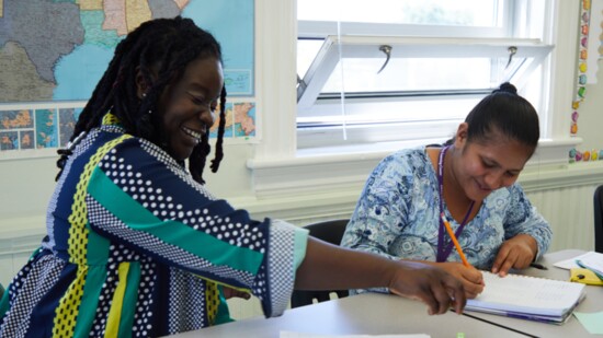 Anika Walker, the adult education program facilitator, working with a student.