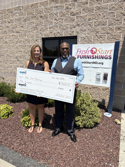 Izak Battle presenting a check to Fresh Start Furnishings. Photo courtesy of APGFCU. 