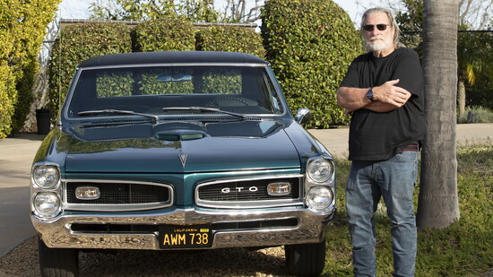Larry Preston standing beside his 1966 Pontiac GTO.