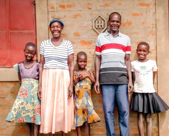 The Okumu Family in front of their new home