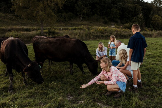 With his family as they tend to cattle on the farm.