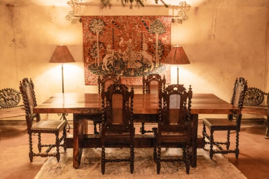 In the tasting room, a solid walnut table handcrafted by the homeowner's father takes center stage, surrounded by antique murals from Belgium and France. 
