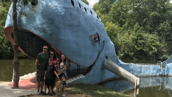 The Barnett family pose in front of the iconic Blue Whale at Catoosa. Matilda (Tilly), a Norman Animal Shelter rescue, is their canine companion.