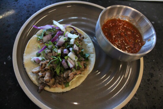 This taco from El Mezquite Grill and Taquiera is piled high with confit brisket and paired with their house salsa.
