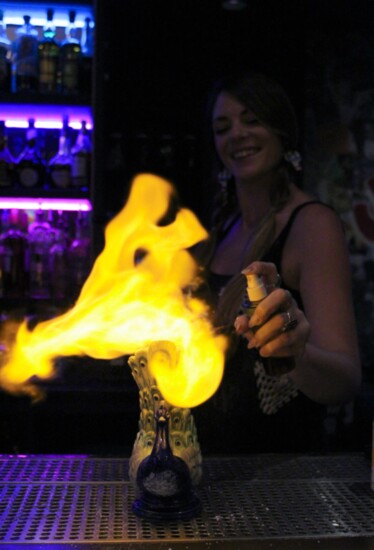 A bartender at The Delta sets fire to their signature cocktail, Killer Parties Never Killed Me.