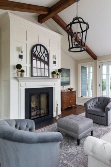 Renovated sitting room with new paneled fireplace and rustic beams