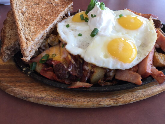 105 Café – Hearty breakfast skillet with eggs, toast, and country-style potatoes.