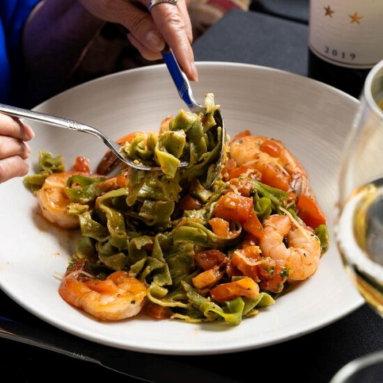 Amore Fine Dining & Spirits – Handmade pasta with shrimp, fresh tomato, and a glass of wine.