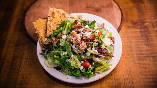 Pacific Yard House – Fresh garden salad topped with grilled shrimp and feta with flatbread.
