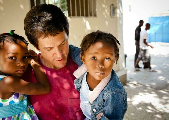 Albom with children at the Have Faith Haiti Mission