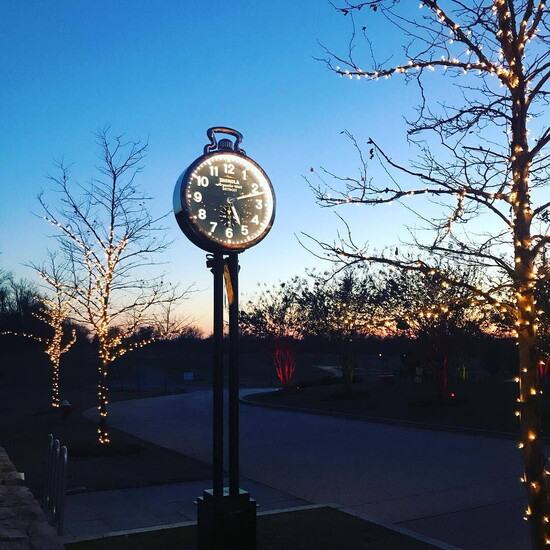 The exterior clock and twinkling outdoor lighting make for a beautiful evening scene.