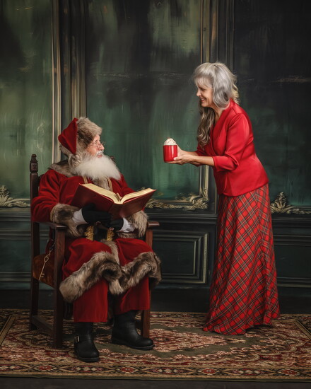 Mrs. Claus offers Santa a cup of hot cocoa.