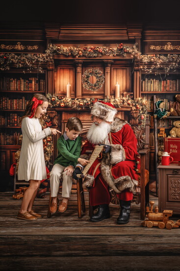 Santa shows childrent their names on the Nice List. 