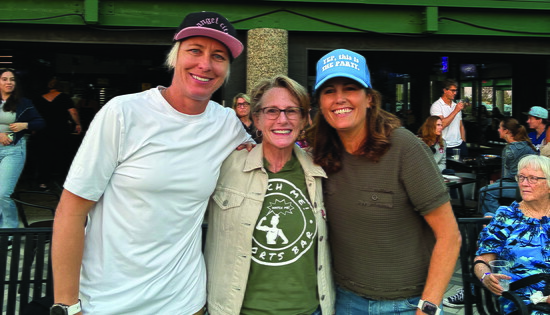 Abby Wambach, left, and Julie Foudy, right, visit Watch Me! Sports Bar with owner Jax Diener.