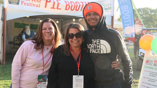 Jessica Olander, center, flanked by two volunteers at the 2024 Apple Harvest & Music Festival