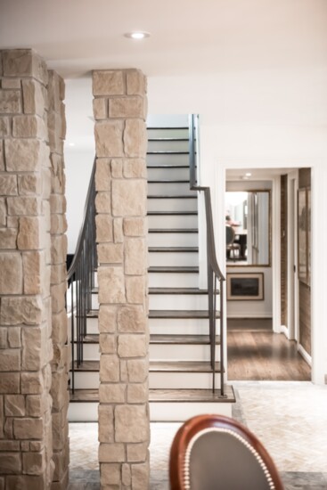 Pillars encased in limestone and a natural stone floor bring a sense of place to the foyer of this home designed by Kelly Gale Amen. Photo by Sergio Santos