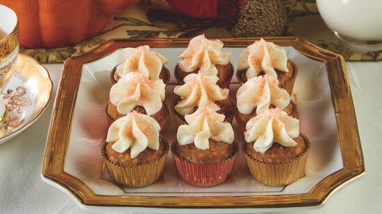Carrot Cake Mini Muffins from The Harmony of Tea are topped with Easy Cream Cheese Frosting and finished with orange sanding sugar.