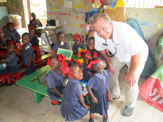 Surrounded by smiles, Allen Speers visits with schoolchildren in Haiti, a reminder of the lives touched by Agape’s work.