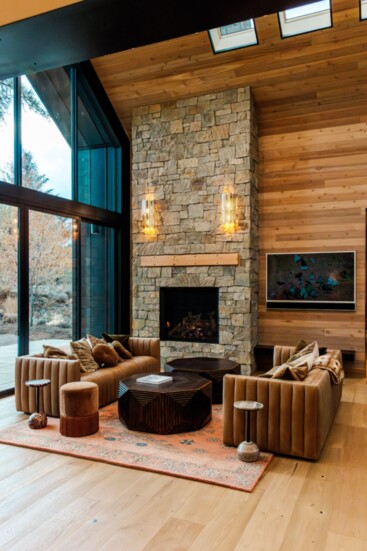 Floor to ceiling windows invite the beauty of the outdoors inside this majestic living space. 