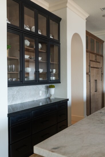 Alternating black and natural wood cabinets with Venaria Reale countertops and back splash provide clean new lines updating a tradition Mediterranean kitchen.