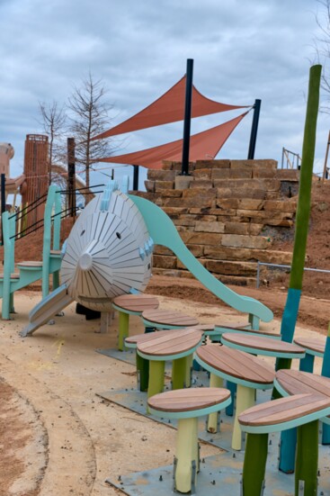 The play areas include interactive wooden creatures designed by Monstrum 