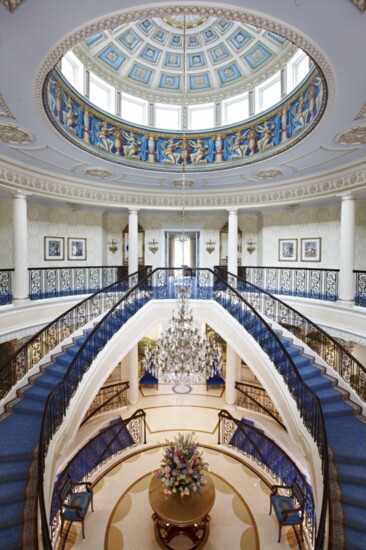 The home's grand entrance feature's sweeping double staircases and a painted dome. 