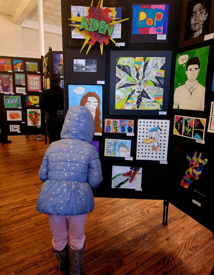 Young attendee viewing art at the annual Greeley Creative District Youth Arts Walk in 2023