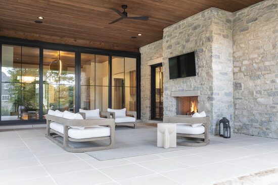 A fire roars in the loggia, a harmonious blend of natural stone, wood siding and custom metalwork.