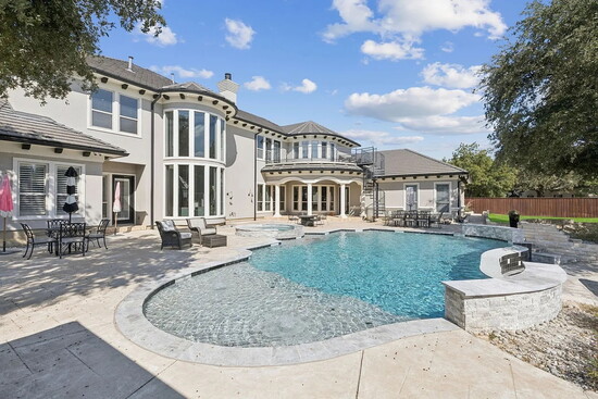 Step out to a backyard sanctuary and the estate transforms into a private resort complete with a negative‑edge pool.