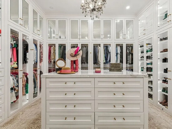 The gorgeous custom walk‑in closet with illuminated built‑ins—an elegant blend of beauty and functionality.