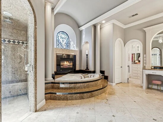 The spa‑inspired ensuite includes dual vanities, a jetted tub, a separate shower, and a custom closet.