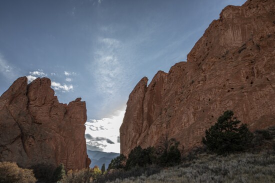 The sun setting between the rock formations.