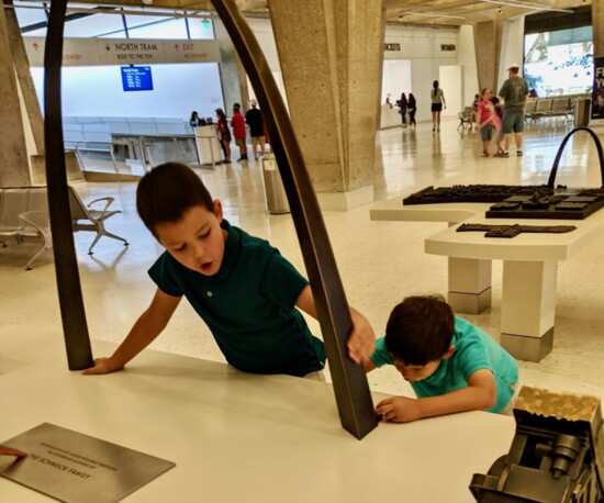 Will and George exploring a model replica of the Gateway Arch.