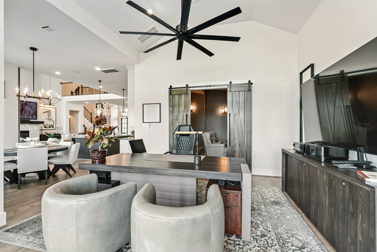 This flexible living area doubles as a stylish workspace, with dramatic barn doors that slide open to reveal the media room.