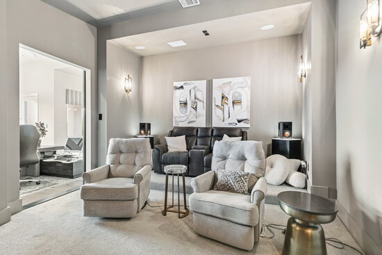 The media room delivers a true cinematic experience with surround sound, recessed lighting, and space for reclining seating.