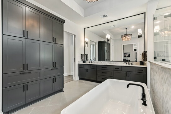 The spa-inspired primary bath offers dual vanities, a freestanding soaking tub, and a walk-in shower framed in marble tile.