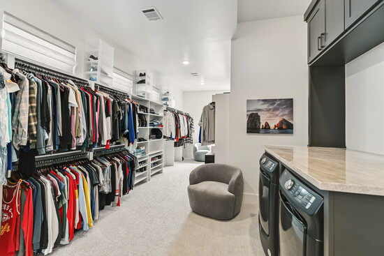 An oversized walk-in closet with built-in organization keeps everything neatly in place. In-closet laundry adds everyday ease to luxury space.