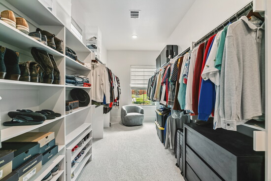 An oversized walk-in closet with built-in organization keeps everything neatly in place. 