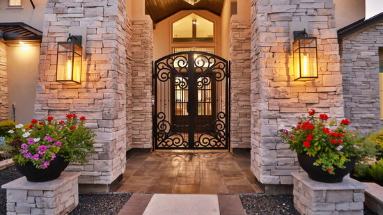  Grand stone entryway with warm lantern lighting and manicured landscaping. It’s a striking introduction that sets the tone for the luxury and comfort inside.