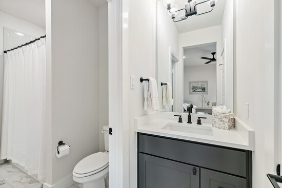A full secondary bathroom features modern fixtures, fresh finishes, and a shower/tub combo for convenience.