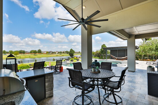 A covered patio and pergola extend the outdoor living areas, creating a seamless flow for gatherings.