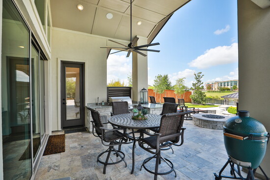 A covered patio and pergola extend the outdoor living areas, creating a seamless flow for gatherings.