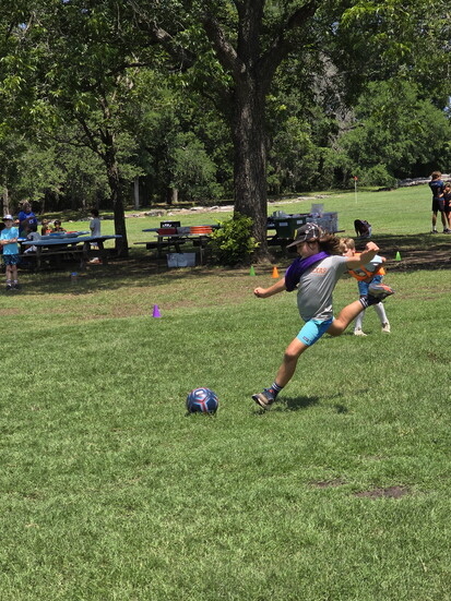 Campers play a competitive game of soccer.