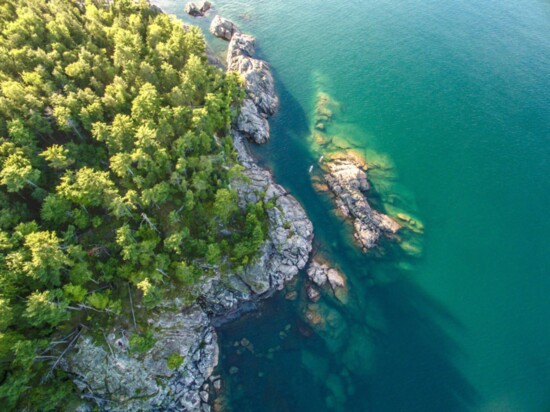 The rocky shore and clear blue waters of Lake Superior