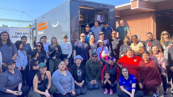 Long Beach community members help fill one of more than 20 trucks sent to LA to aid families in need.