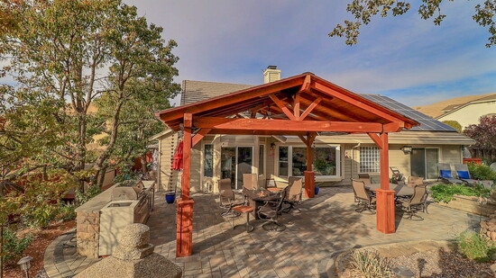 A custom-built pergola featuring exquisite wood open-beam craftsmanship now graces the backyard.