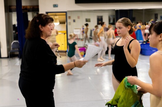 Laura Reinschmidt talks with dancers during rehearsal. 
