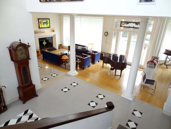Light filled first floor living room with maple floor and antique furniture setting.